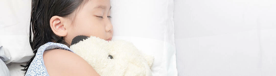  2021/10/child-in-bed-1080.jpg cute little asian girl sleep and hug doll on bed in the bedroom., top view