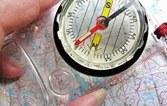  2021/10/map-compass-245.jpg Close-up of person holding compass over map