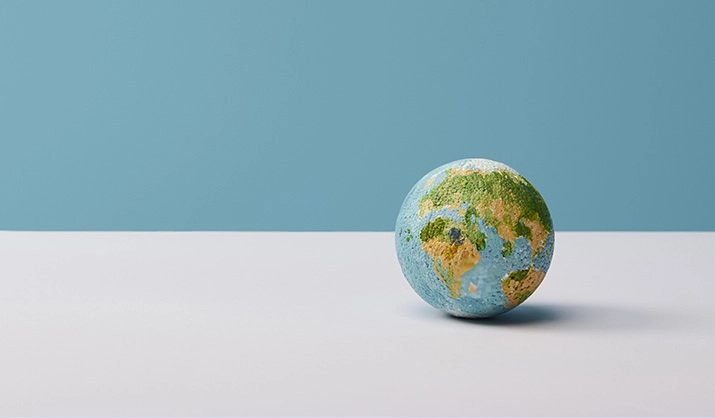small globe on white table and blue background