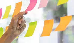  2021/10/sticky-notes-plans-245.jpg business people post it notes in glass wall at meeting room