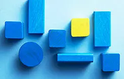  2021/10/wooden-blocks-245.jpg Blue and yellow wooden cubes over blue background, top view