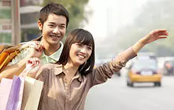  2021/10/young-couple-hailing-taxi-Beijing-245-.jpg Young couple with shopping bags hailing a taxicab in Beijing