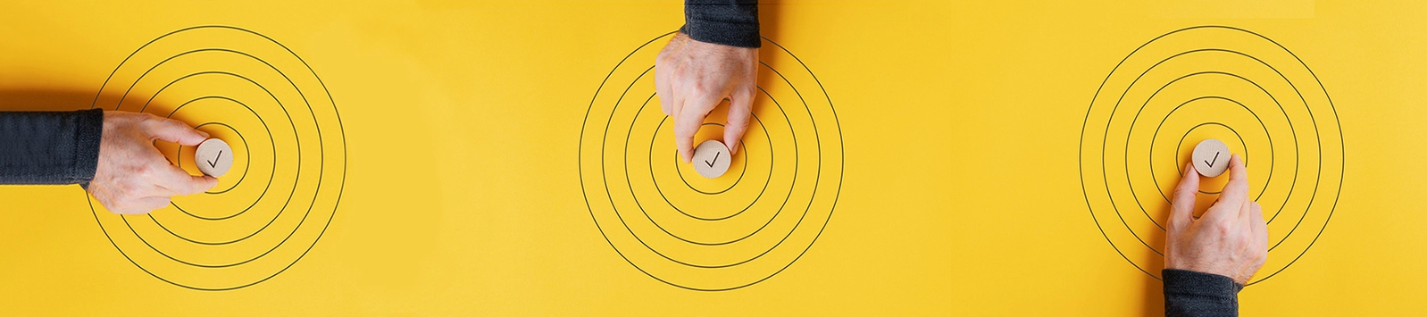 hand placing a wooden circle with checkmark in the middle of hand-drawn target