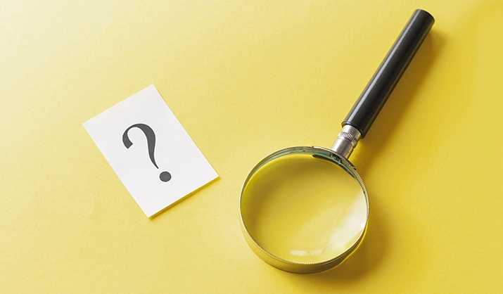Magnifying glass with printed question mark
