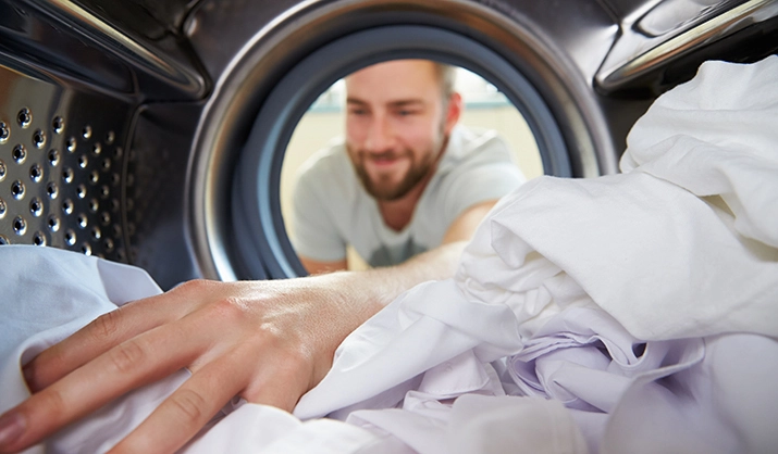 Man Reaching Inside Washing Machine
