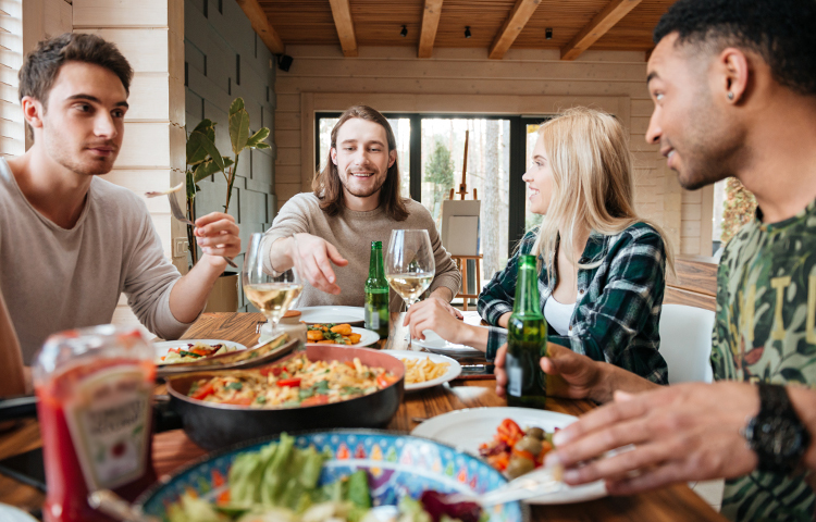 A group of happy friends eating and talking at the dinner table