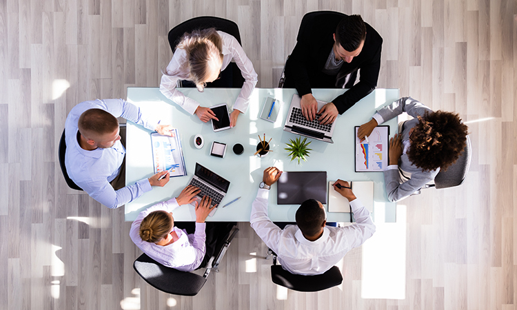 Overhead view of business people collaborating around conference table