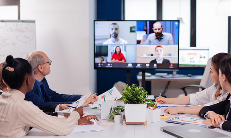 employees meeting in conference room during video call