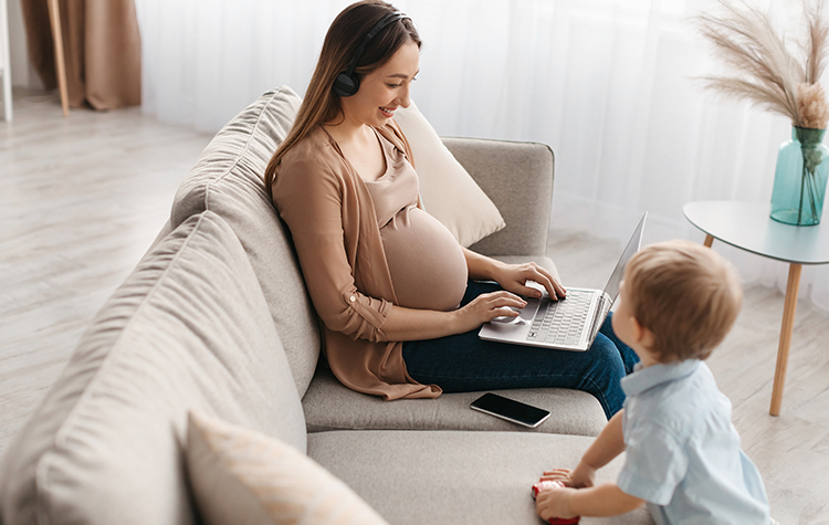 Pregnant woman researching on laptop 