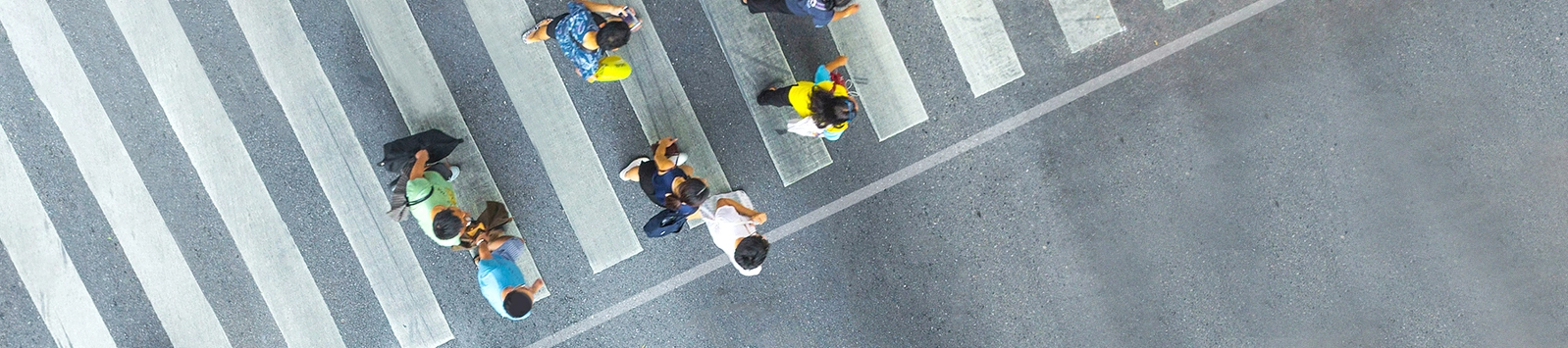 a busy group of people in crosswalk, seen from overhead