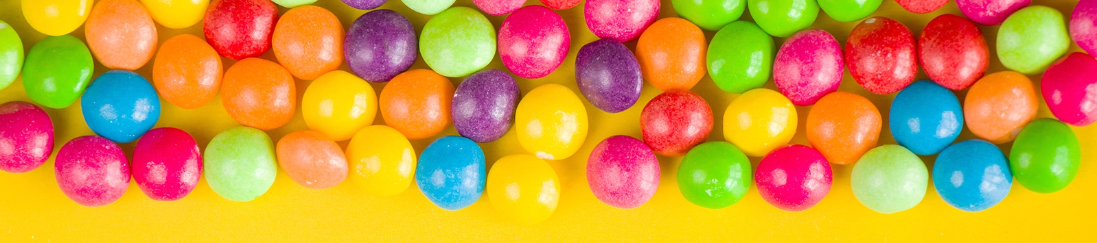 colorful fruit candy on yellow background