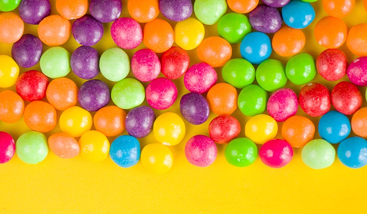colorful fruit candy on yellow background