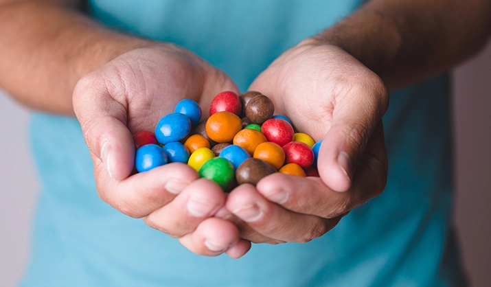 Male hands holding colored candies