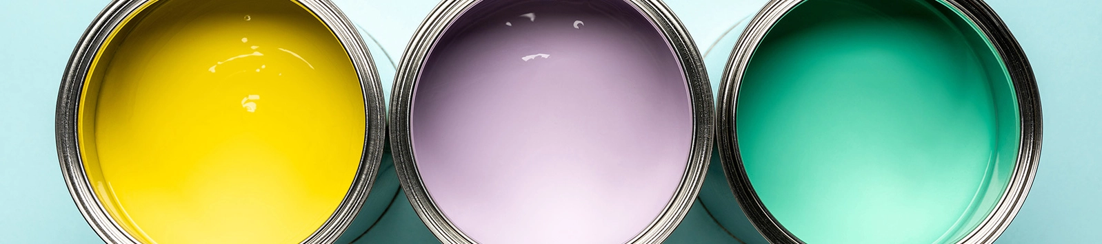 top view of three cans of paint on blue surface