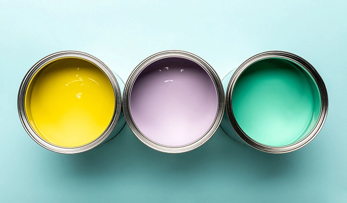 top view of three cans of paint on blue surface